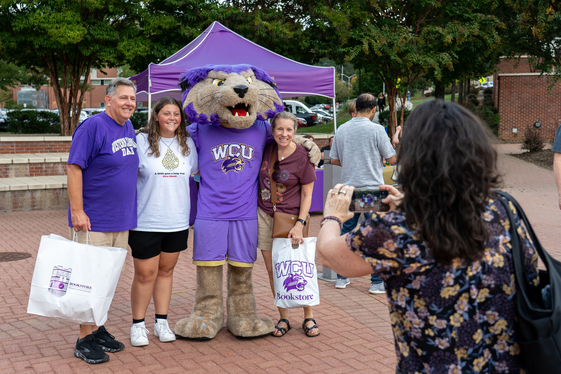 Family photo with Paws in front of WCU backdrop