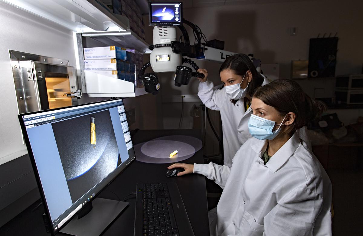 Forensic science students working with equipment in a lab 