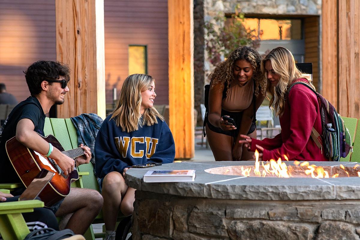 Students hanging out around the fire pit at the Rocks dormitory