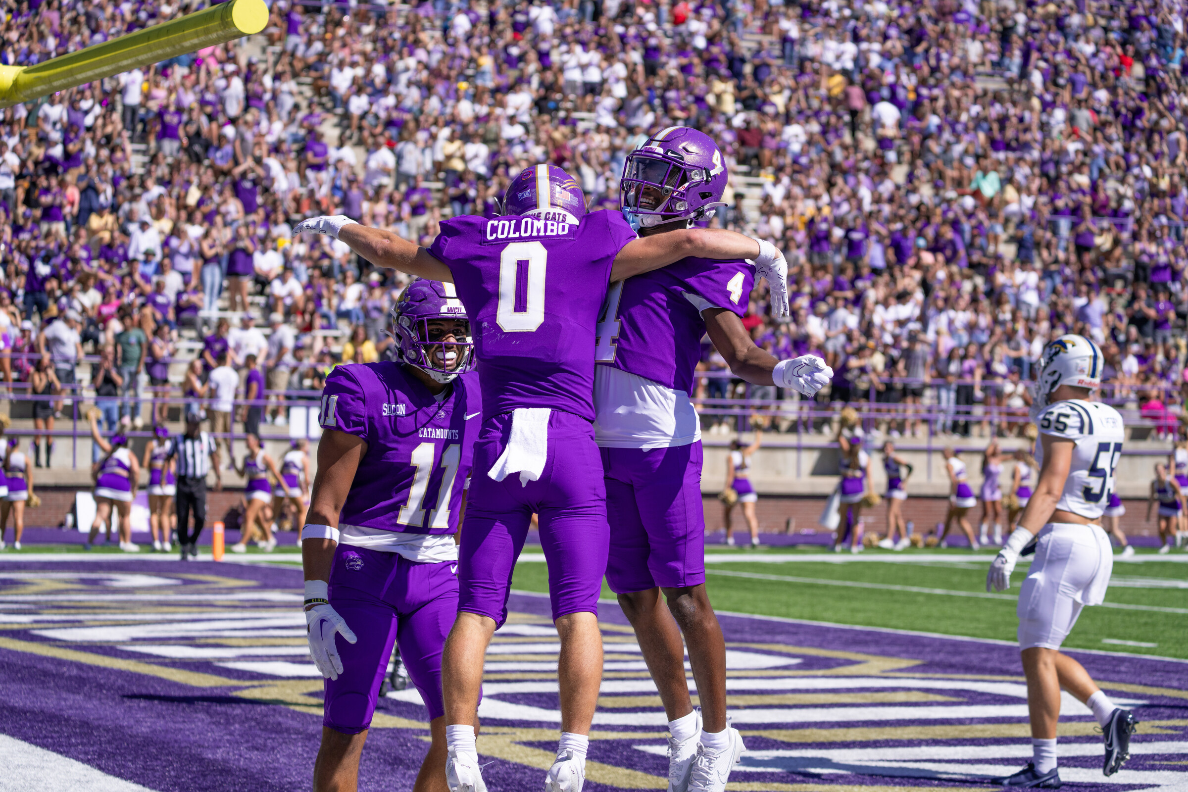 Football players jumping in celebration in the in zone. 