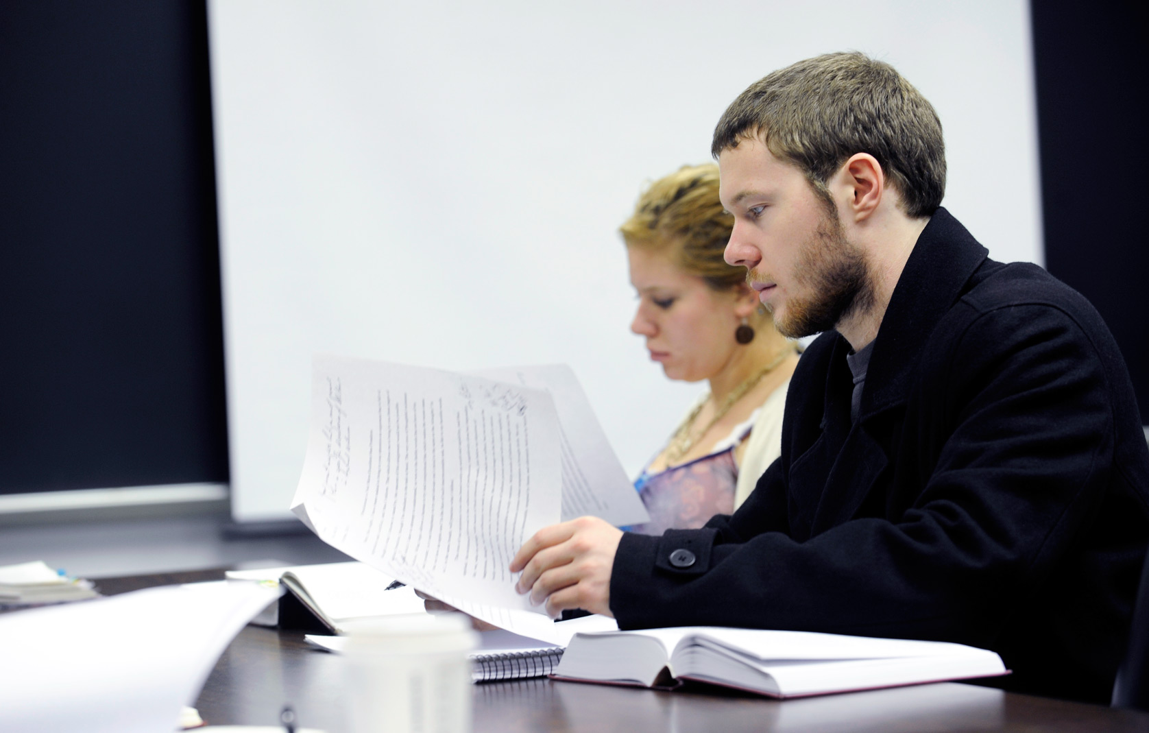 Student reading over material at a table in class