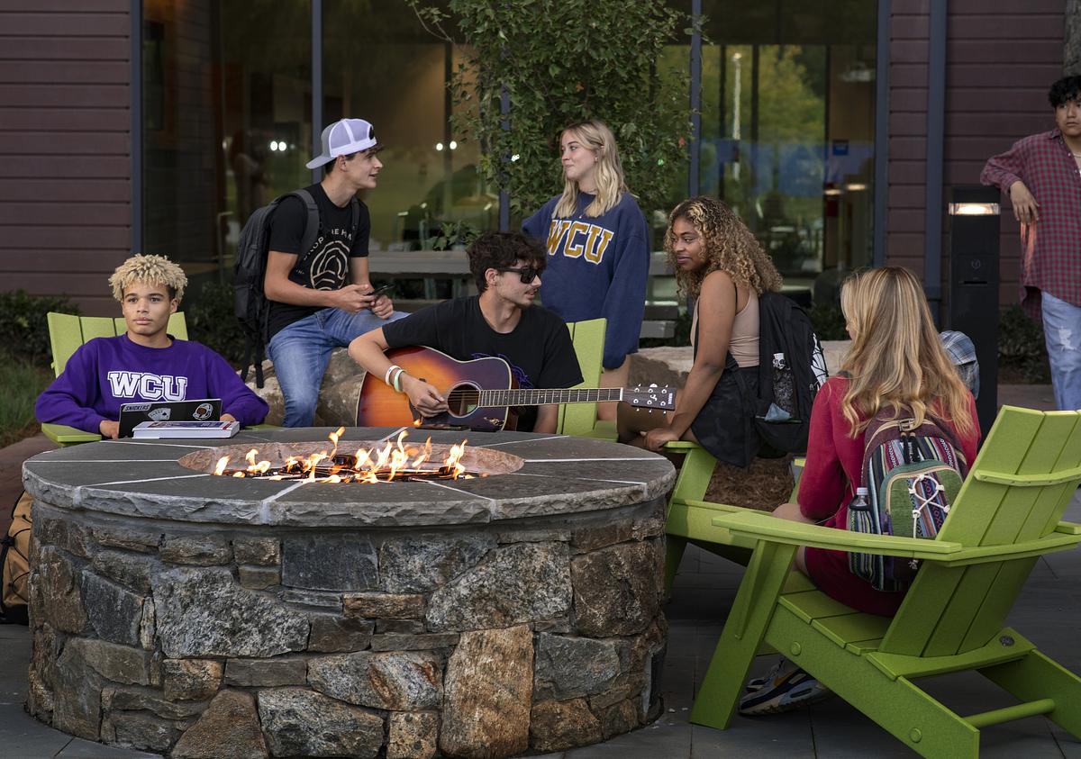 students sitting around firepit