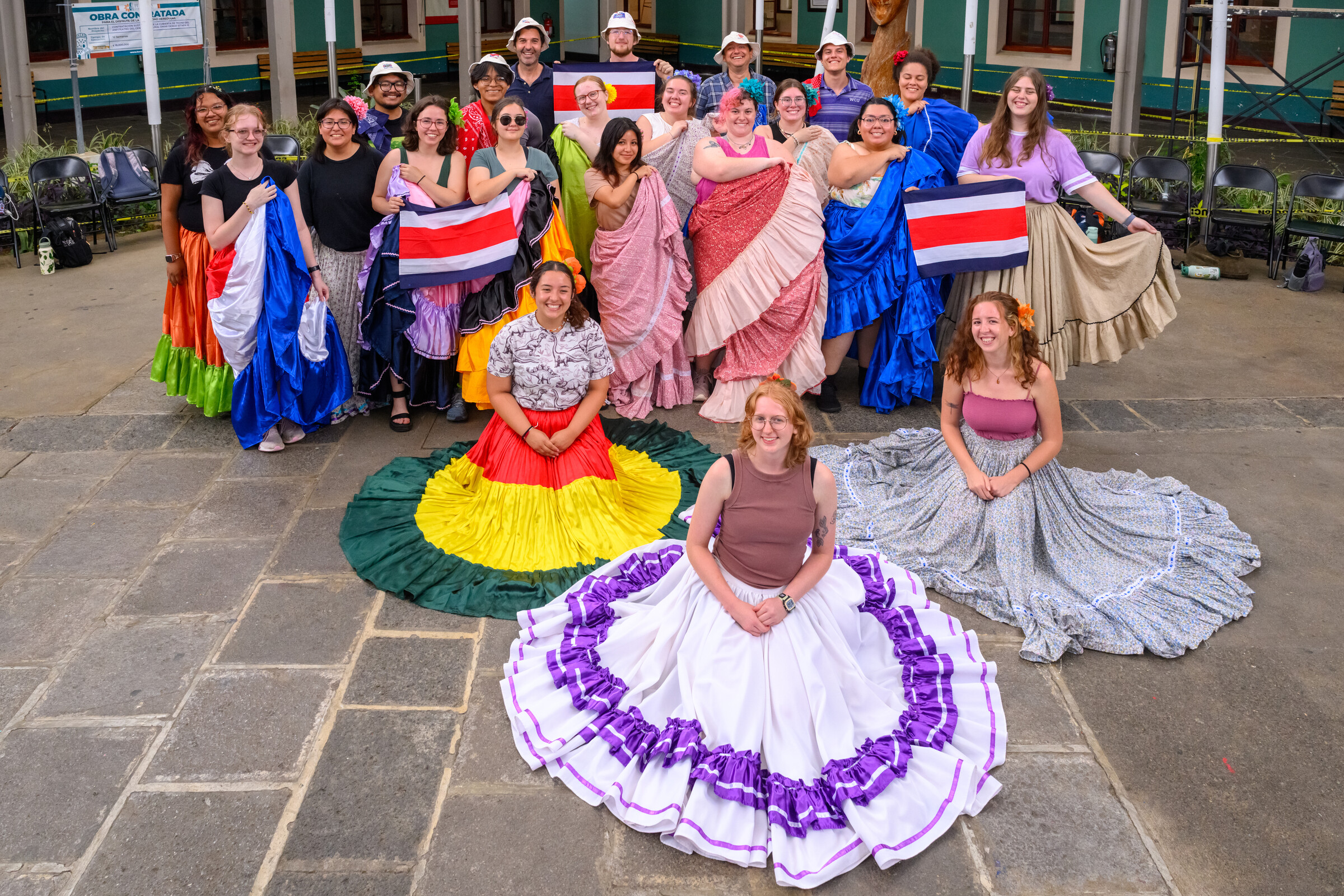 Students on a study abroad trip posing for the camera in colorful dresses. 