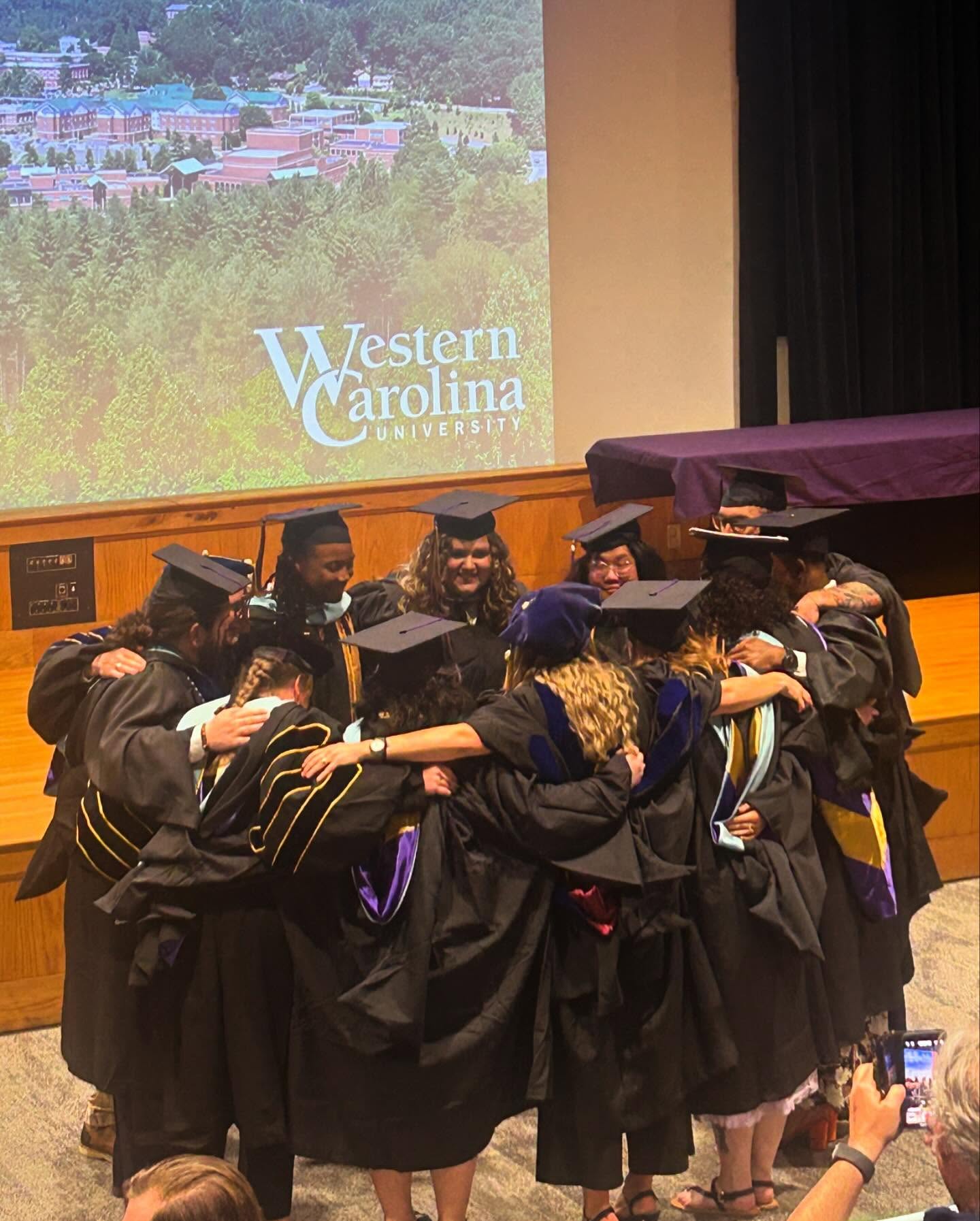 Graduating students gathered together in a circle celebrating their achievements 