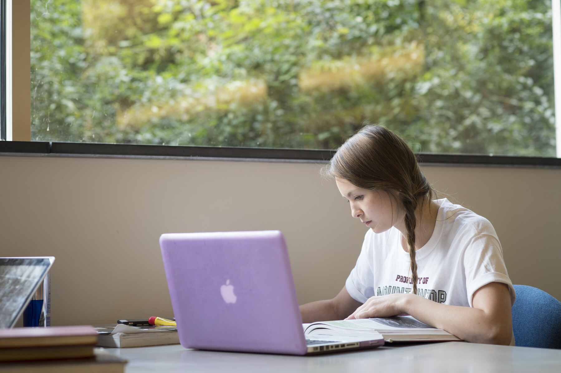 Student working on a laptop with a purple cover